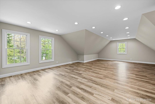 additional living space featuring baseboards, vaulted ceiling, and wood finished floors