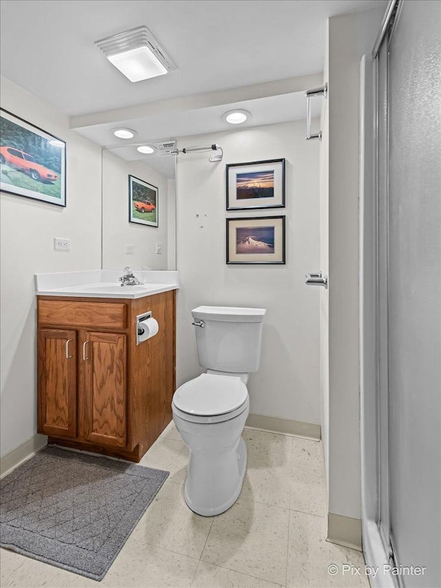 bathroom with baseboards, vanity, and toilet