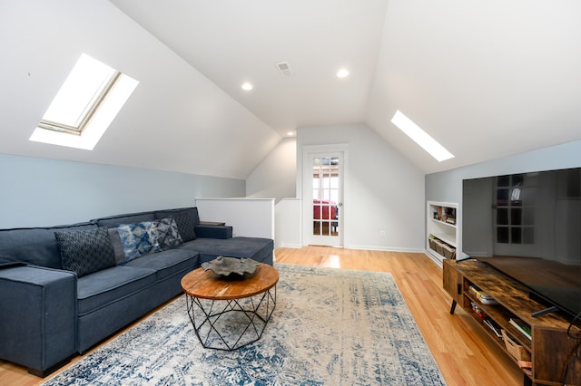 living room featuring light wood finished floors, recessed lighting, visible vents, and lofted ceiling with skylight