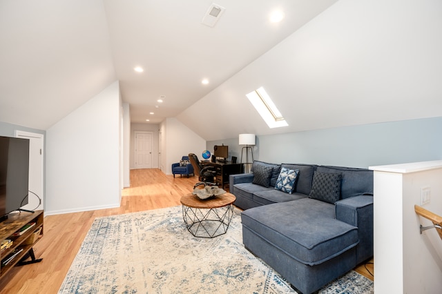 living room featuring visible vents, recessed lighting, vaulted ceiling with skylight, and light wood-style floors