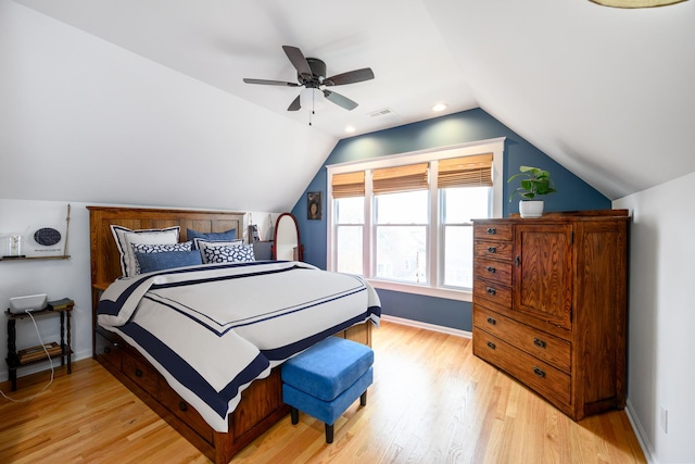 bedroom with visible vents, baseboards, light wood finished floors, and vaulted ceiling