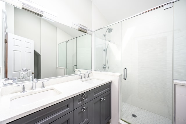full bathroom featuring a shower stall, double vanity, and a sink