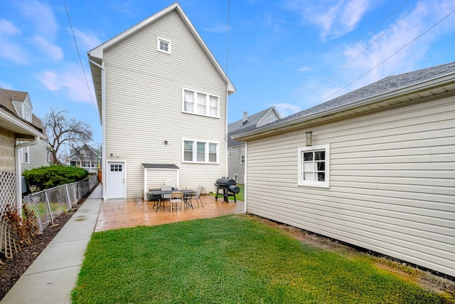 back of house featuring a yard, a patio area, and fence