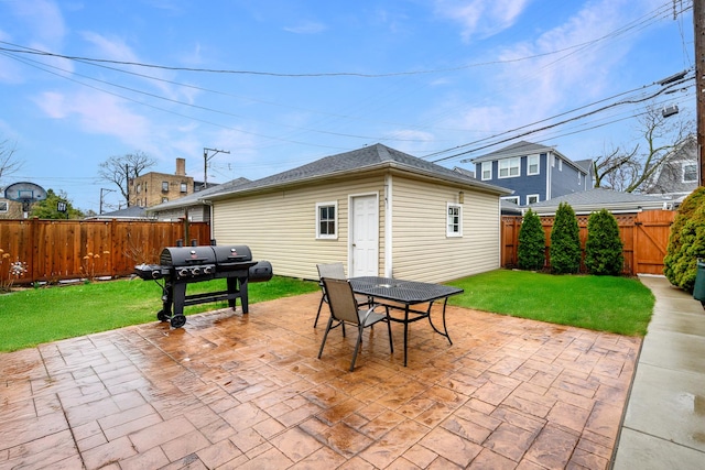 view of patio with an outbuilding, a fenced backyard, outdoor dining space, and area for grilling
