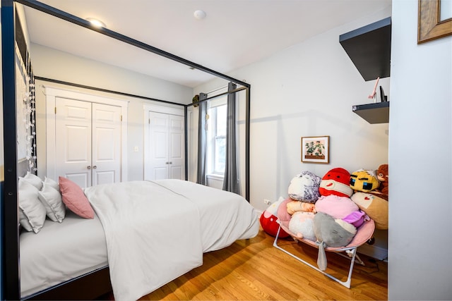 bedroom with light wood-style flooring and two closets