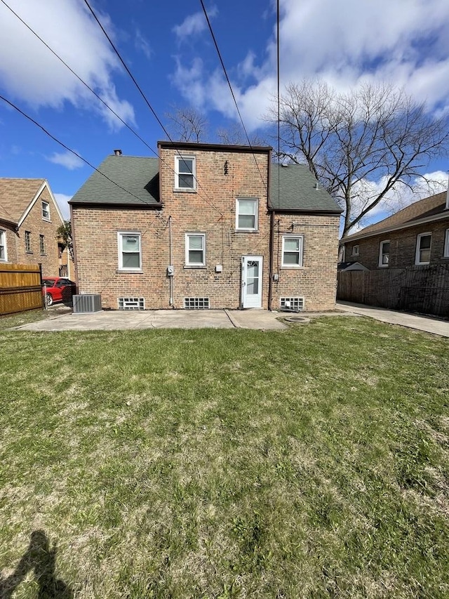 rear view of property featuring a patio, central AC, fence, and a lawn