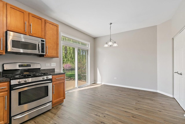 591 Waterford Rd, Elgin, IL 60124 - kitchen with stainless steel appliances, a chandelier, light wood finished floors, brown cabinetry, and baseboards