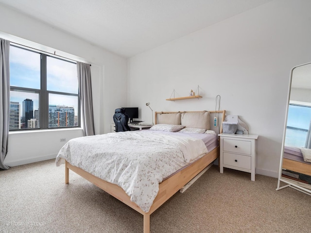 bedroom with baseboards and light carpet