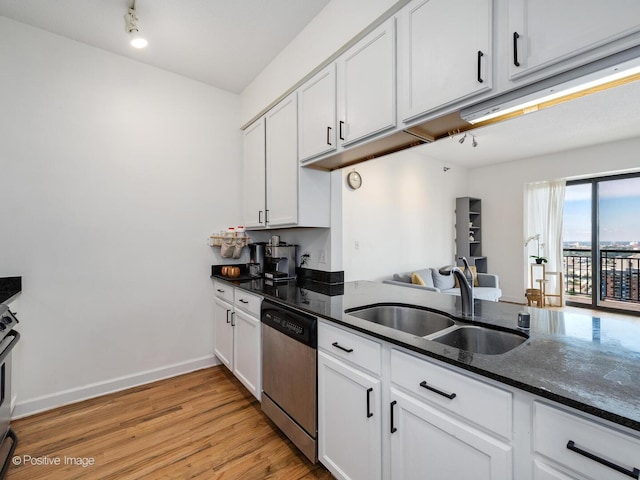 kitchen featuring light wood-style flooring, white cabinets, dark stone countertops, dishwasher, and a sink