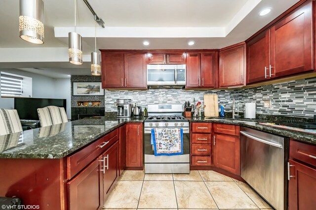 kitchen featuring a peninsula, stainless steel appliances, reddish brown cabinets, and tasteful backsplash