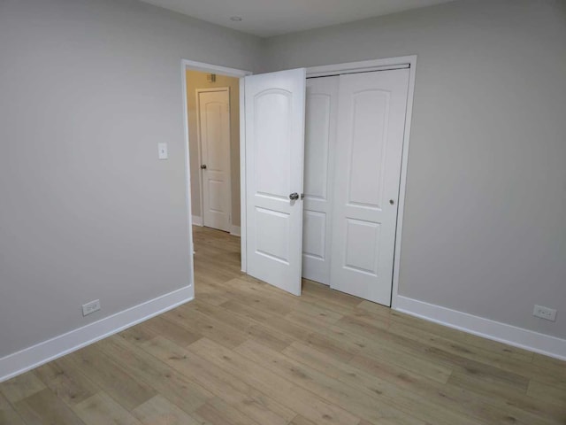 16117 Wolcott Ave, Markham, IL 60428 - unfurnished bedroom with a closet, light wood-style flooring, and baseboards