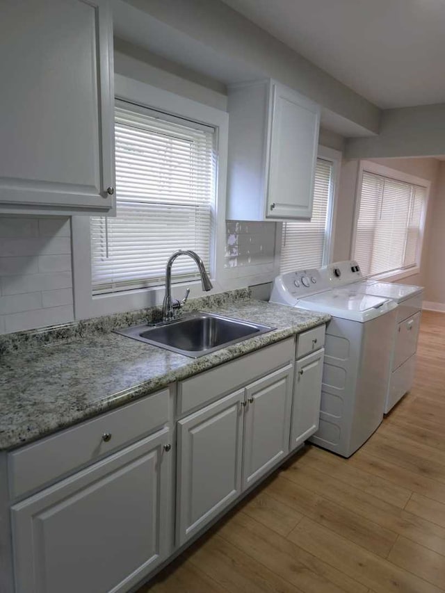 16117 Wolcott Ave, Markham, IL 60428 - kitchen featuring light wood-style flooring, white cabinets, independent washer and dryer, decorative backsplash, and a sink