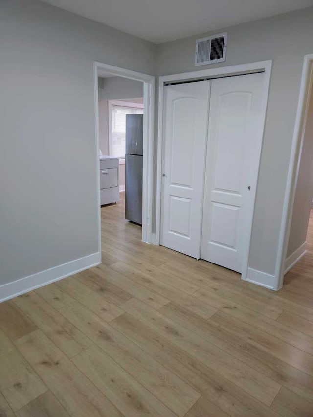 16117 Wolcott Ave, Markham, IL 60428 - unfurnished bedroom with light wood finished floors, freestanding refrigerator, baseboards, and visible vents