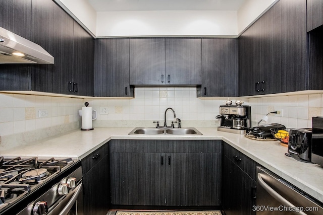 kitchen with tasteful backsplash, light countertops, stainless steel appliances, range hood, and a sink