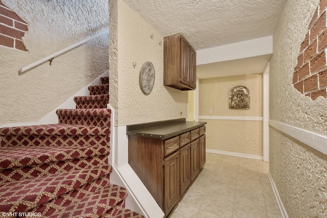 6920 N Avers Ave, Lincolnwood, IL 60712 - stairway featuring a textured wall, a textured ceiling, and baseboards