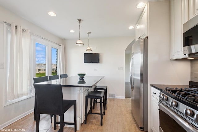 6920 N Avers Ave, Lincolnwood, IL 60712 - kitchen featuring arched walkways, dark countertops, visible vents, recessed lighting, and appliances with stainless steel finishes