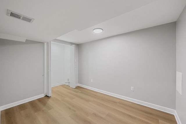 finished below grade area with baseboards, visible vents, and light wood-style flooring