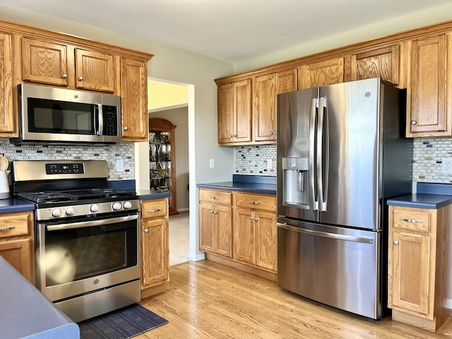 102 W Auburndale Ave, Cortland, IL 60112 - kitchen featuring dark countertops, backsplash, stainless steel appliances, and light wood-style flooring
