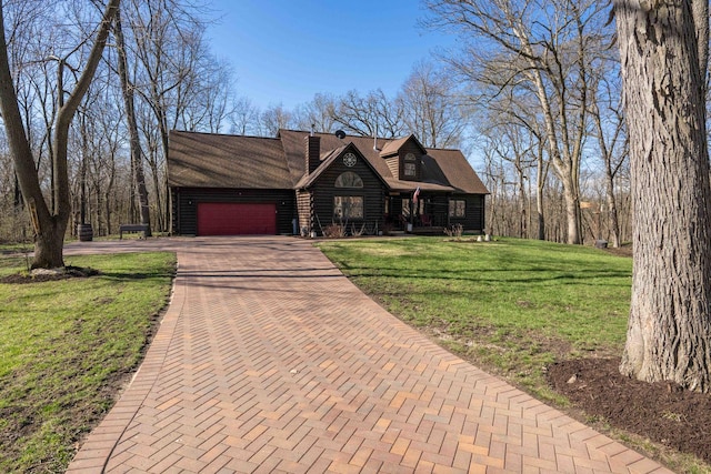 view of front facade with roof with shingles, log siding, an attached garage, a front yard, and decorative driveway