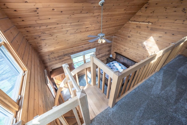living room featuring wood ceiling, ceiling fan, vaulted ceiling, and wooden walls