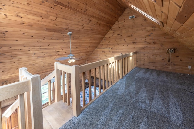 corridor with wood ceiling, wooden walls, carpet, and lofted ceiling