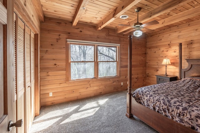 bedroom with wood ceiling, wood walls, carpet floors, and beamed ceiling