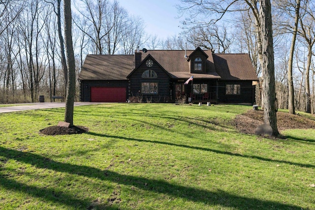view of front of property with concrete driveway, an attached garage, log siding, and a front yard