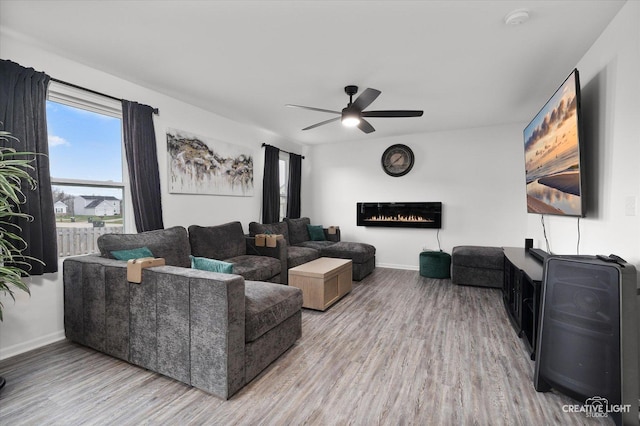 927 Hyte St, Plano, IL 60545 - living room with baseboards, a ceiling fan, a glass covered fireplace, and wood finished floors