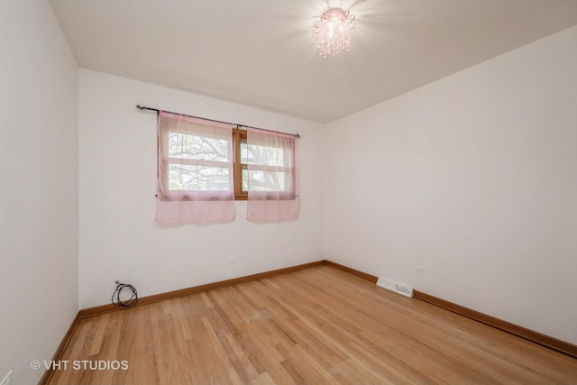 spare room featuring light wood-style floors and baseboards