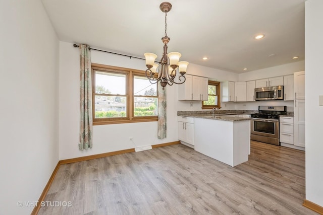 kitchen with appliances with stainless steel finishes, a chandelier, a sink, baseboards, and recessed lighting