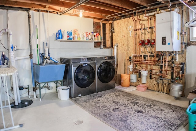 laundry room with water heater, washer and dryer, laundry area, and a sink