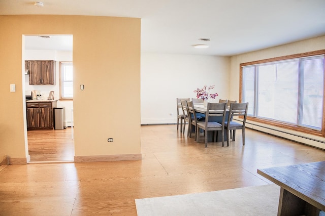 dining room with a baseboard heating unit, baseboards, light wood-style floors, visible vents, and a baseboard radiator