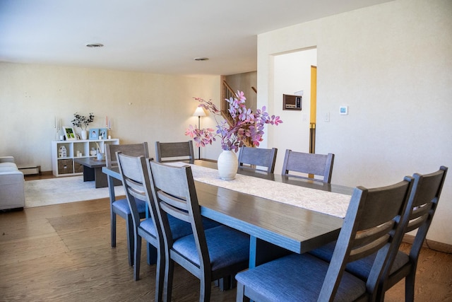 dining room with visible vents, wood finished floors, and baseboard heating
