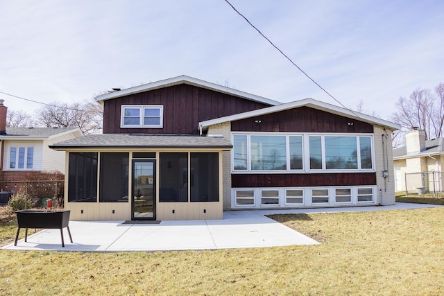 rear view of house with a lawn, a sunroom, fence, and a patio area