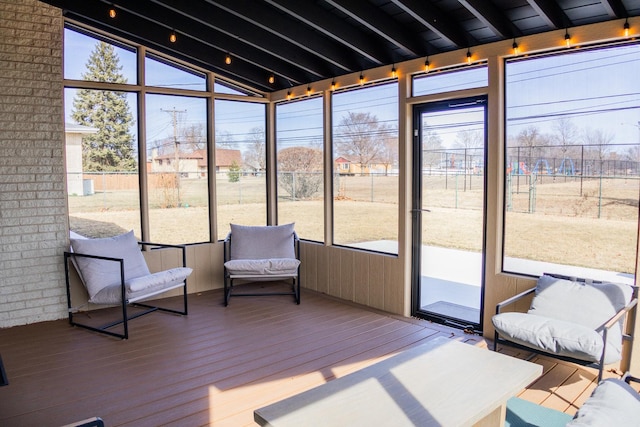 unfurnished sunroom featuring beamed ceiling