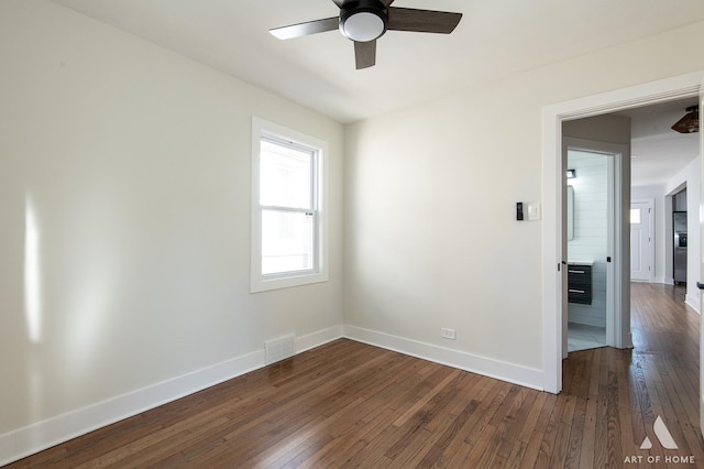 unfurnished room with baseboards, visible vents, ceiling fan, and dark wood-type flooring