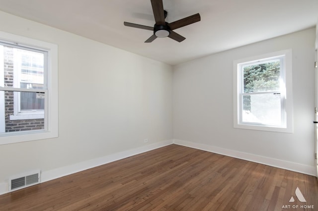unfurnished room with wood finished floors, baseboards, ceiling fan, and visible vents