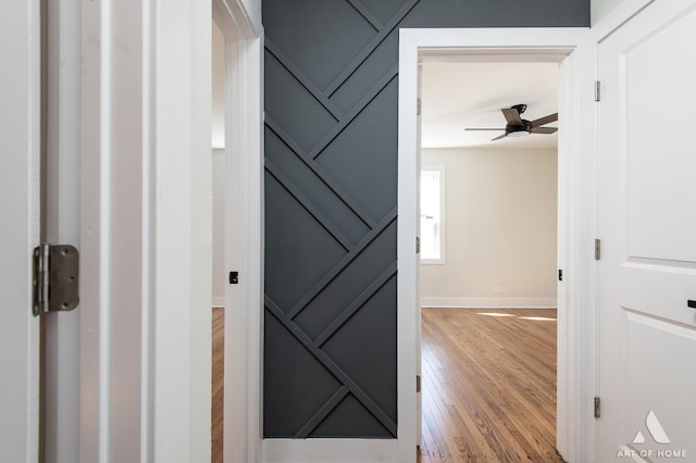 hallway featuring baseboards and wood finished floors
