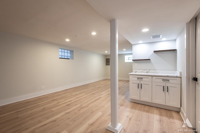 basement with recessed lighting, baseboards, light wood-style floors, and visible vents