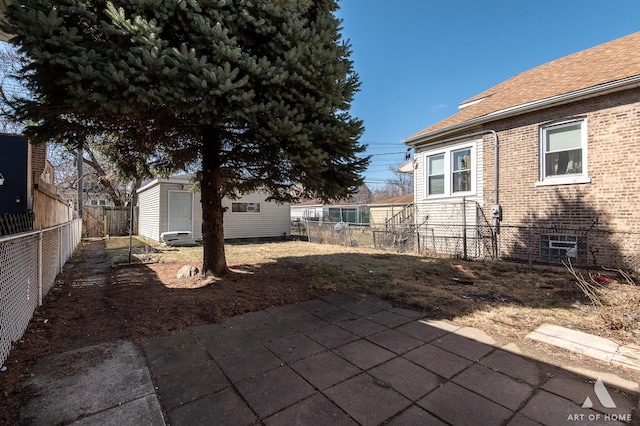 view of yard featuring a fenced backyard, a storage unit, an outdoor structure, and a patio