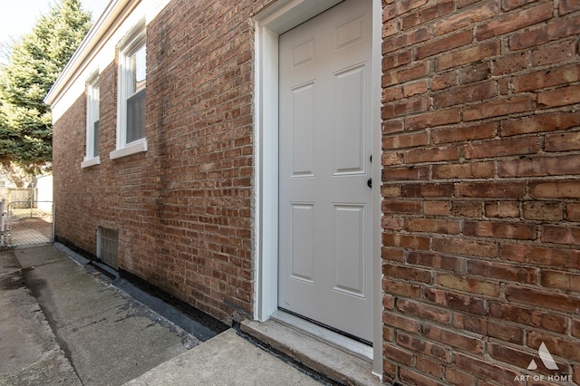 view of exterior entry featuring brick siding