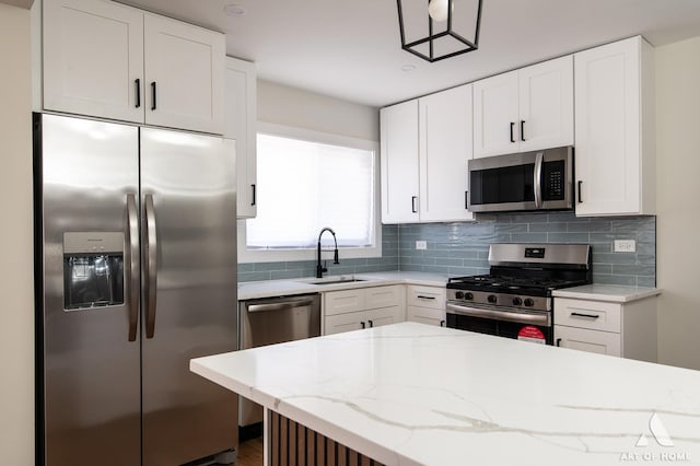 kitchen with a sink, tasteful backsplash, appliances with stainless steel finishes, and white cabinets