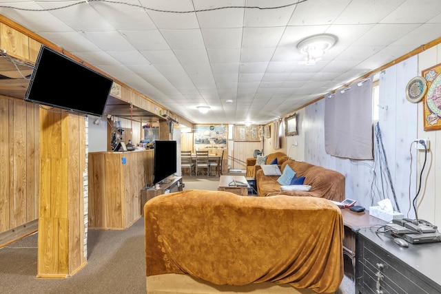 carpeted living room with wood walls