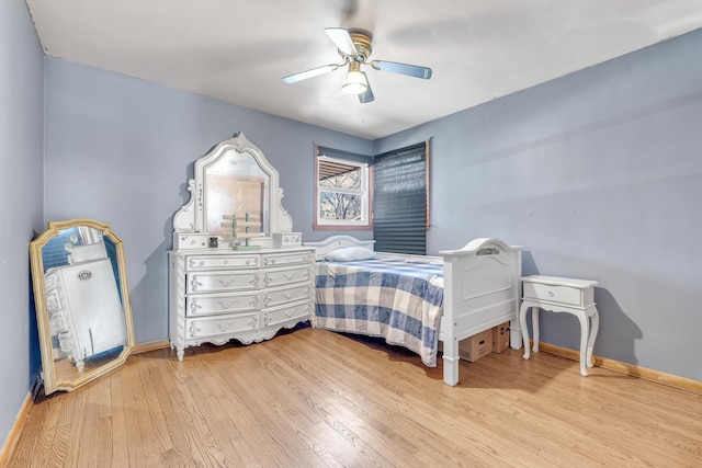 bedroom featuring a ceiling fan, baseboards, and wood finished floors