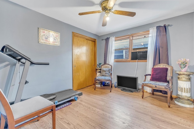 workout area featuring light wood-type flooring, cooling unit, and ceiling fan