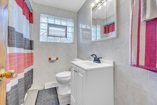 bathroom featuring visible vents, toilet, vanity, and tile walls