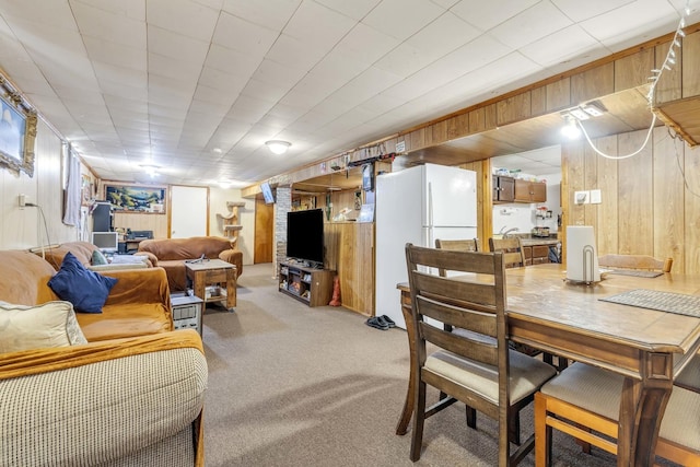 dining area with light colored carpet and wood walls
