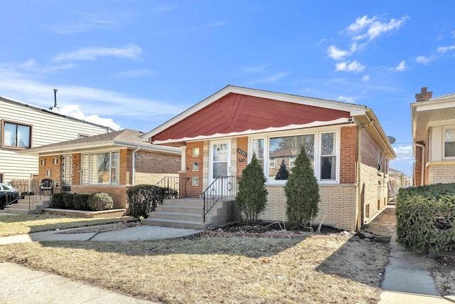 bungalow featuring brick siding