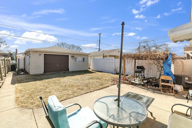 view of patio / terrace with an outdoor structure, a fenced backyard, a garage, and a grill