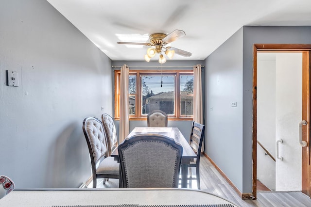 dining room featuring baseboards, wood finished floors, and a ceiling fan